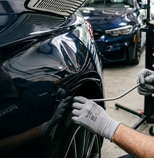 Débosselage sans peinture sur un véhicule dans un atelier de carrosserie à Lévis.